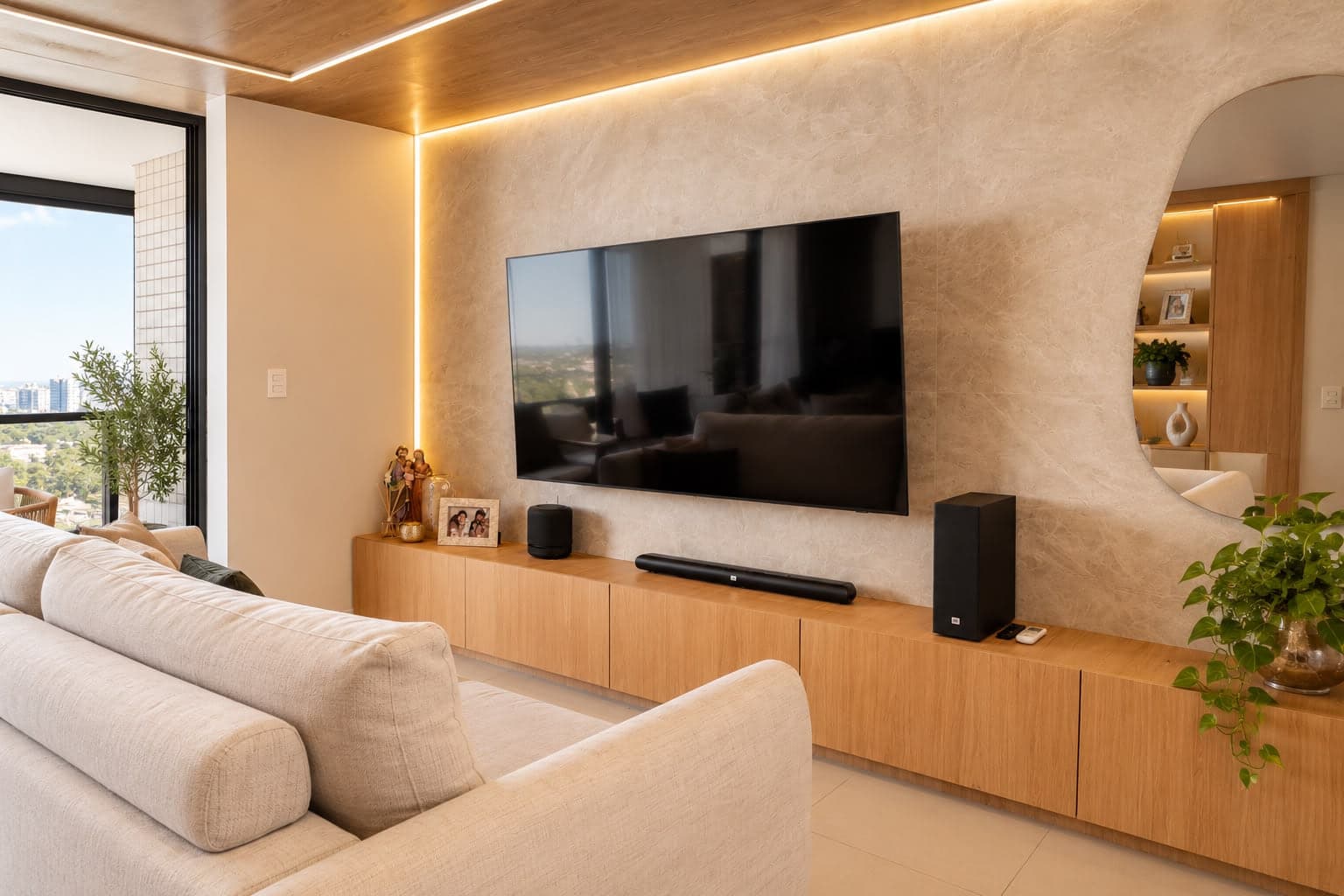 Sala de estar com painel de pedra clara atrás da TV desligada, rack baixo de madeira corrido e nicho arredondado iluminado.